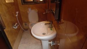 a bathroom with a toilet and a sink at Bright Star Hotel in Arusha