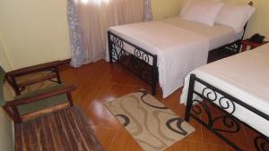 a room with two beds and a wooden floor at Bright Star Hotel in Arusha