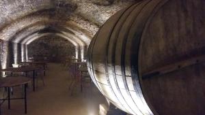 a wine cellar with tables and a large wine barrel at El Lagar de La Navazuela in La Rasa