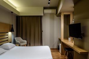a hotel room with a bed and a television at Agamemnon Hotel in Nafplio