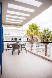 een balkon met een tafel en stoelen en palmbomen bij B06 - Top-Floor Marina 2 bed Apartment in Lagos