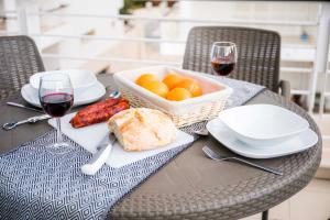 een tafel met een mand met eten en glazen wijn bij B06 - Top-Floor Marina 2 bed Apartment in Lagos