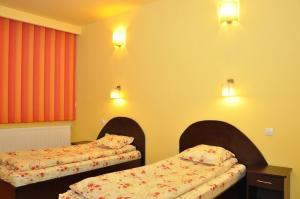 Habitación con 2 camas en una habitación en Hotel Coliseum en Calafat