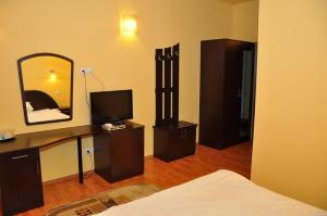 Habitación con dormitorio con cama y espejo. en Hotel Coliseum, en Calafat