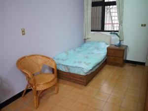 1 dormitorio pequeño con 1 cama pequeña y 1 silla en 1969 - Elixir of Love en Tainan