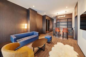 uma sala de estar com um sofá azul e cadeiras em Skybay Hotel Gyeongpo em Gangneung