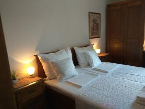 Schlafzimmer mit einem Bett mit weißer Bettwäsche und Kissen in der Unterkunft Apartment Alea in Portorož