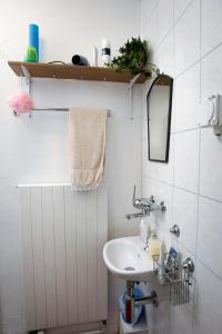 ein Bad mit einem Waschbecken und einem Spiegel in der Unterkunft Bed&Breakfast Pinocchio in Seuzach