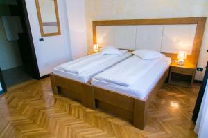 una camera da letto con un grande letto con lenzuola bianche di White House a Făgăraş