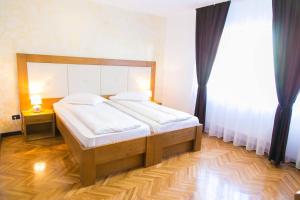 una camera da letto con un grande letto con lenzuola bianche di White House a Făgăraş