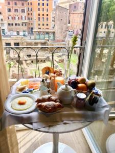 ローマにあるMaison Torre Argentinaのバルコニーに朝食用の食材を用意した朝食用テーブル