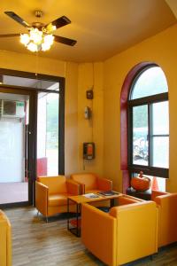 a living room with orange chairs and a table at Shinyes Motel in Suao