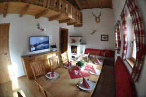 a living room with a dining table and a television at Chalet Freiraum in Kleinarl