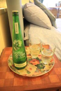 オールストンにあるGilderdaleの緑のボトルとテーブルの上にグラス2杯