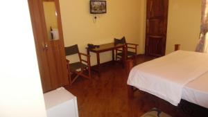 a bedroom with a bed and a table and chairs at Bright Star Hotel in Arusha