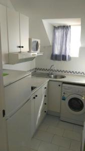 een witte keuken met een wastafel en een wasmachine bij Apartamento Década Cervantes 19 in Fuengirola