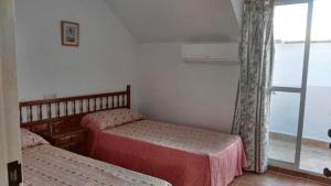 een slaapkamer met 2 bedden en een raam bij Apartamento Década Cervantes 19 in Fuengirola