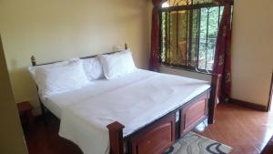 a bed with white sheets and a window in a room at Bright Star Hotel in Arusha