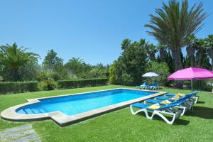 una piscina con sillas y sombrillas en un patio en Owl Booking Villa Bobis - Family Holidays with Private Pool, en Port de Pollença (Puerto Pollensa)