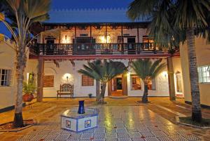 a courtyard with palm trees in front of a building at Kaskazi Beach house in Msambweni