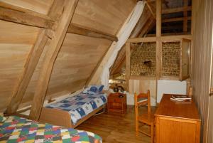 um quarto com uma cama e uma secretária num sótão em Gîte CoMic em Vidouze