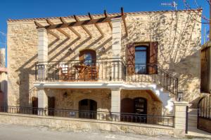 a stone house with a balcony on the side of it at Villa Morfeas - Traditional Cretan Escape with BBQ in Dhamavólos