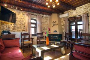 a living room with a table and a fireplace at Villa Morfeas - Traditional Cretan Escape with BBQ in Dhamavólos