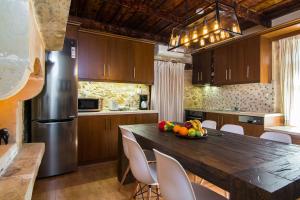 a kitchen with a table with a bowl of fruit on it at Villa Morfeas - Traditional Cretan Escape with BBQ in Dhamavólos