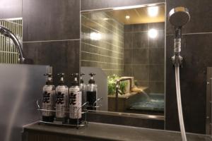 a group of bottles sitting on a counter in a bathroom at Cabin & Capsule Hotel J-SHIP Osaka Namba in Osaka