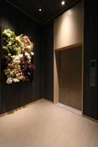 a room with a painting of a plant on the wall at Cabin & Capsule Hotel J-SHIP Osaka Namba in Osaka
