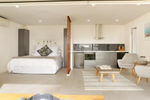 a bedroom with a bed and a living room at The Beach House North Wollongong in Wollongong
