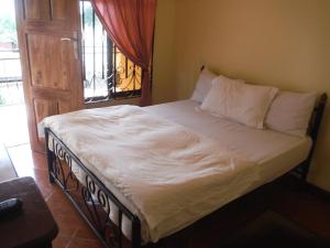 a bed with white sheets and pillows in a bedroom at Bright Star Hotel in Arusha