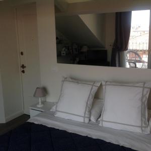 Bett mit weißen Kissen in einem Zimmer mit Fenster in der Unterkunft Apartment Pied à Terre with Terrazza in Milan City Center in Mailand