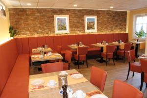 un ristorante con tavoli e sedie e un muro di mattoni di Hotel Burg-Mühle a Gelnhausen