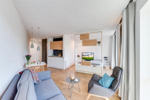 ein Wohnzimmer mit einem blauen Sofa und Stühlen in der Unterkunft SMARTments business Berlin Karlshorst in Berlin