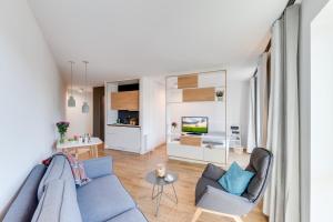 a living room with a blue couch and chairs at SMARTments business Berlin Karlshorst in Berlin