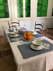 een tafel met een blauwe en witte tafeldoek met sinaasappels erop bij PORTATERRA Antica Dimora in Scorrano