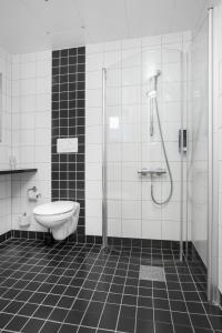 a white toilet sitting next to a shower in a bathroom at Connect Hotel Skavsta Airport in Nyköping