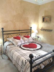 ein Schlafzimmer mit einem Bett mit roten Kissen in der Unterkunft A casa di Gloria in Acqui Terme