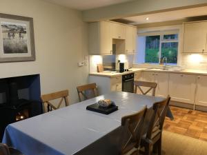 a kitchen with a table with a blue table cloth at Garden Cottage in Carsluith +17 photos