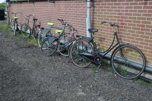 uma fila de bicicletas estacionadas contra uma parede de tijolos em Your nice waggon at the Cow's Paradise em Amsterdã