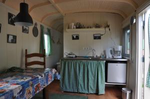 uma cozinha com uma mesa e um lavatório num quarto em Your nice waggon at the Cow's Paradise em Amsterdã