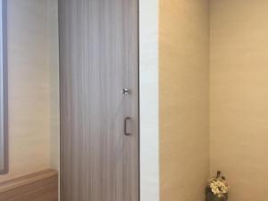 a wooden door in a room next to a wall at Cabin & Capsule Hotel J-SHIP Osaka Namba in Osaka