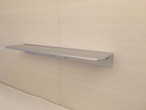 a shelf is attached to a wall at Cabin & Capsule Hotel J-SHIP Osaka Namba in Osaka