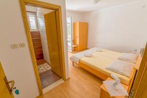 a small bedroom with a bed and a mirror at Rooms Karla in Polače