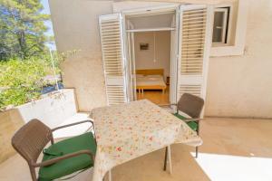 een patio met een tafel en stoelen op een balkon bij Rooms Karla in Polače