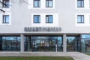 - un grand bâtiment blanc avec un panneau dans l'établissement SMARTments business Berlin Prenzlauer Berg, à Berlin