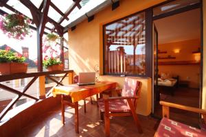 a room with a table and a laptop on a balcony at Pensiunea Hanna in Braşov
