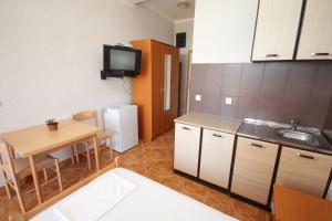 a small kitchen with a small table and a small refrigerator at Apartments DEA in Bar