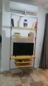 a tv sitting on a shelf in a room at Studio mobiliado in Santos